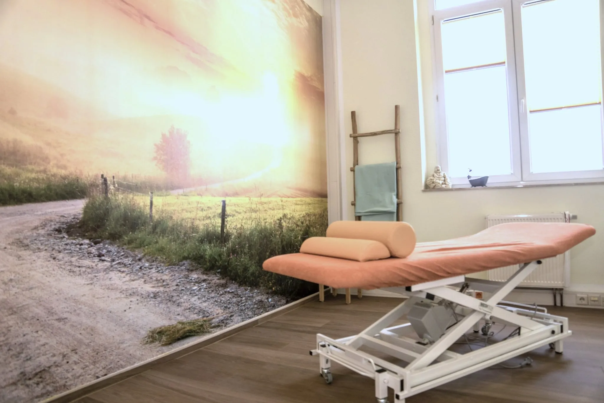 Behandlungsraum mit Wandbild und Therapieliege in Elsterwerda